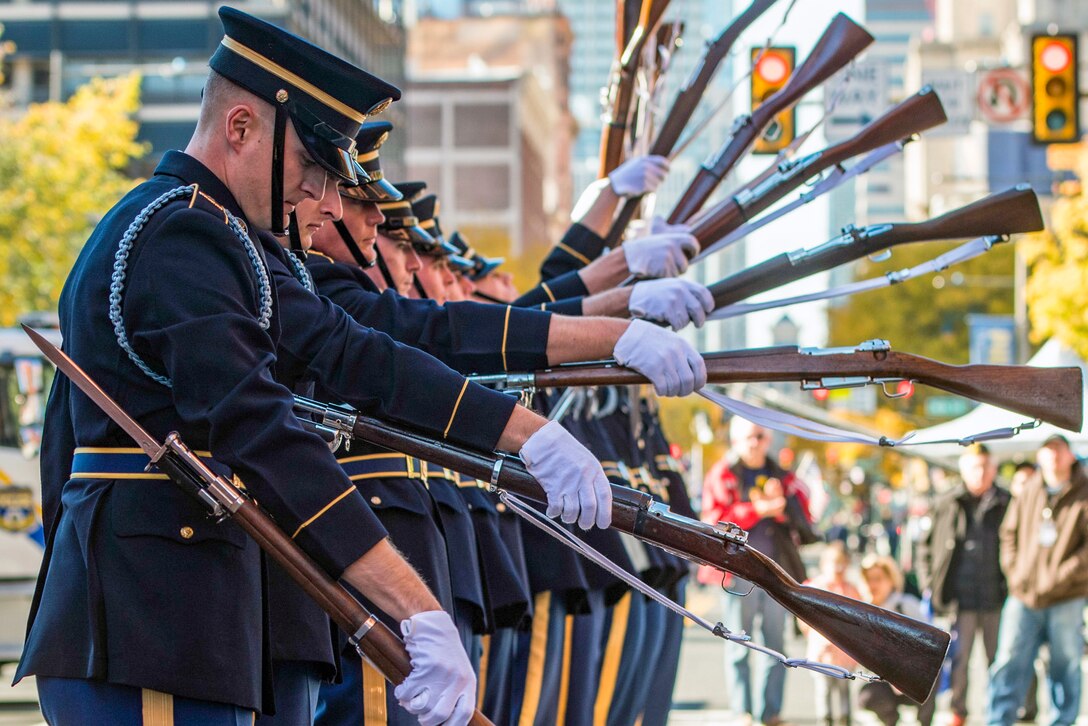 Soldiers spin rifles at the end of a parade.