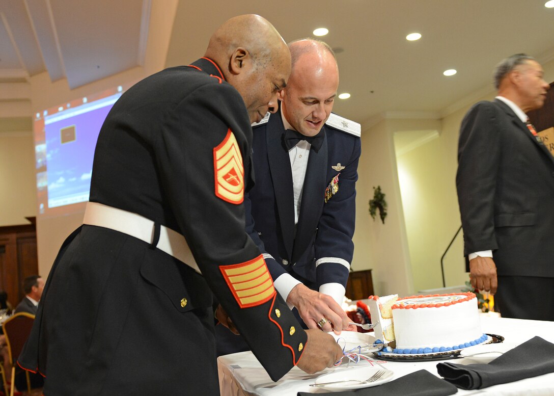 Brig. Gen. E. John Teichert, 412th Test Wing commander, cuts the ceremonial cake with retired Gunnery Sgt. James Baker at the Coffee4Vets Veterans Military Ball at the John P. Eliopulos Hellenic Center in Lancaster, California, Nov. 3. (U.S. Air Force photo by Kenji Thuloweit)