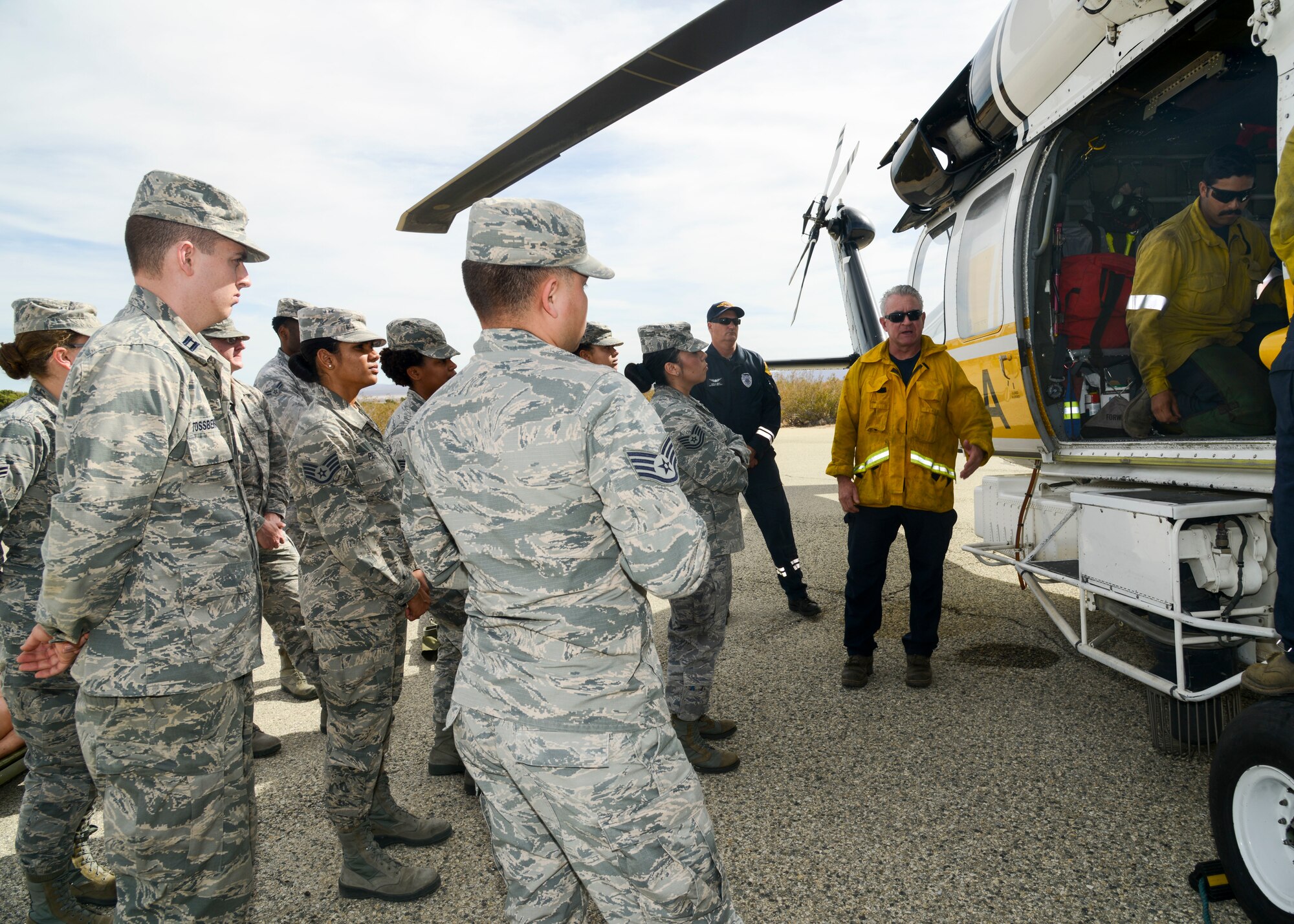 Members of a helicopter crew from the Los Angeles County Fire Department provide helicopter familiarization to Airmen from the 412th Medical Group during a training event at Edwards Air Force Base, California, Nov. 1. Interagency training allows the Airmen to be familiar with the helicopter, its crew and proper medevac standard operating procedures as Edwards AFB does not have native air medevac capabilities. (U.S. Air Force photo by Giancarlo Casem)