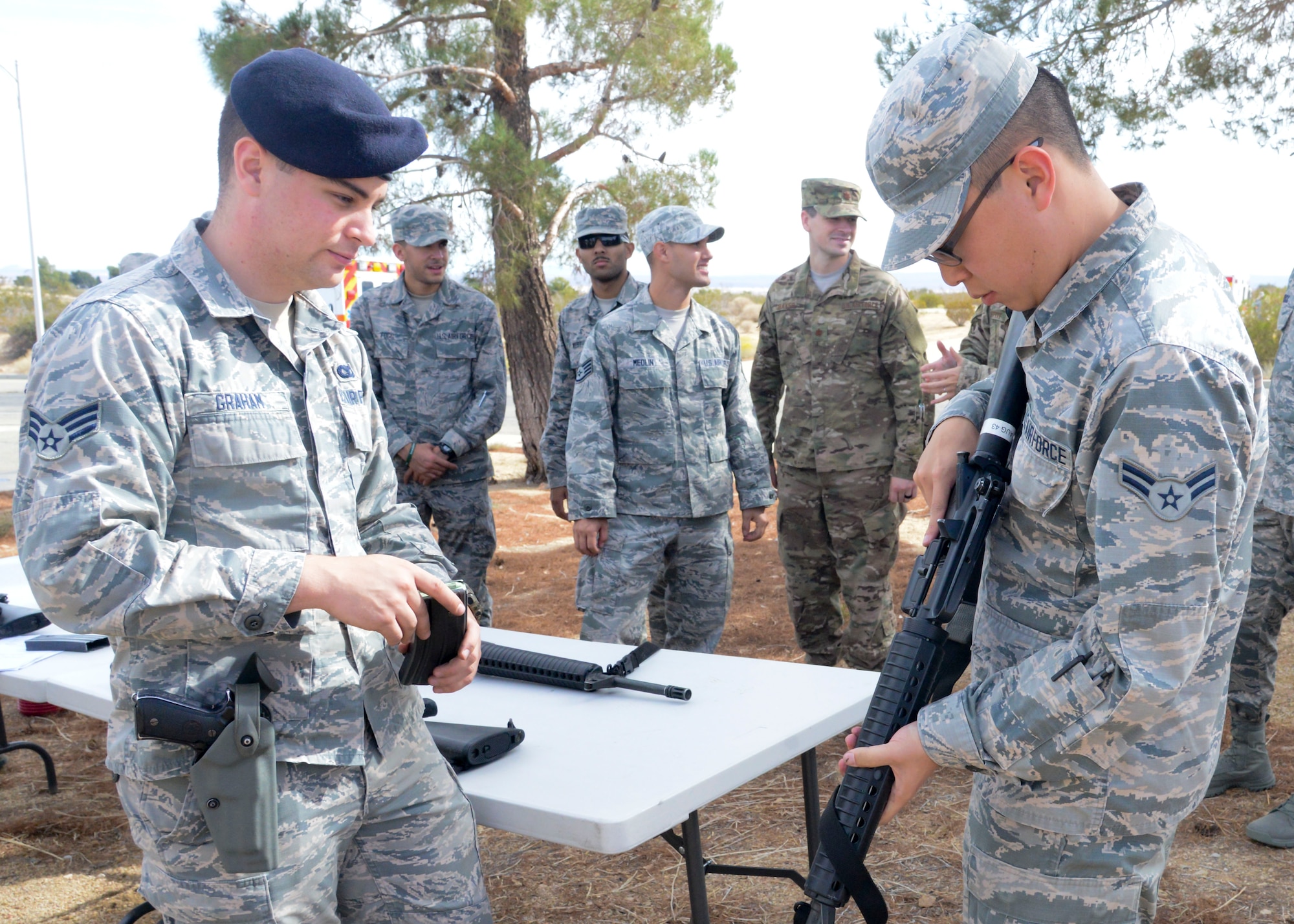 Senior Airman Mark Graham, 412th Security Forces Squadron, provides hands-on training on an M16 rifle to a 412th Medical Group Airman during a training event at Edwards Air Force Base, California, Nov. 1. Weapons training gives the Airmen the basics to react to enemy contact to able to render aid to victims. (U.S. Air Force photo by Giancarlo Casem)