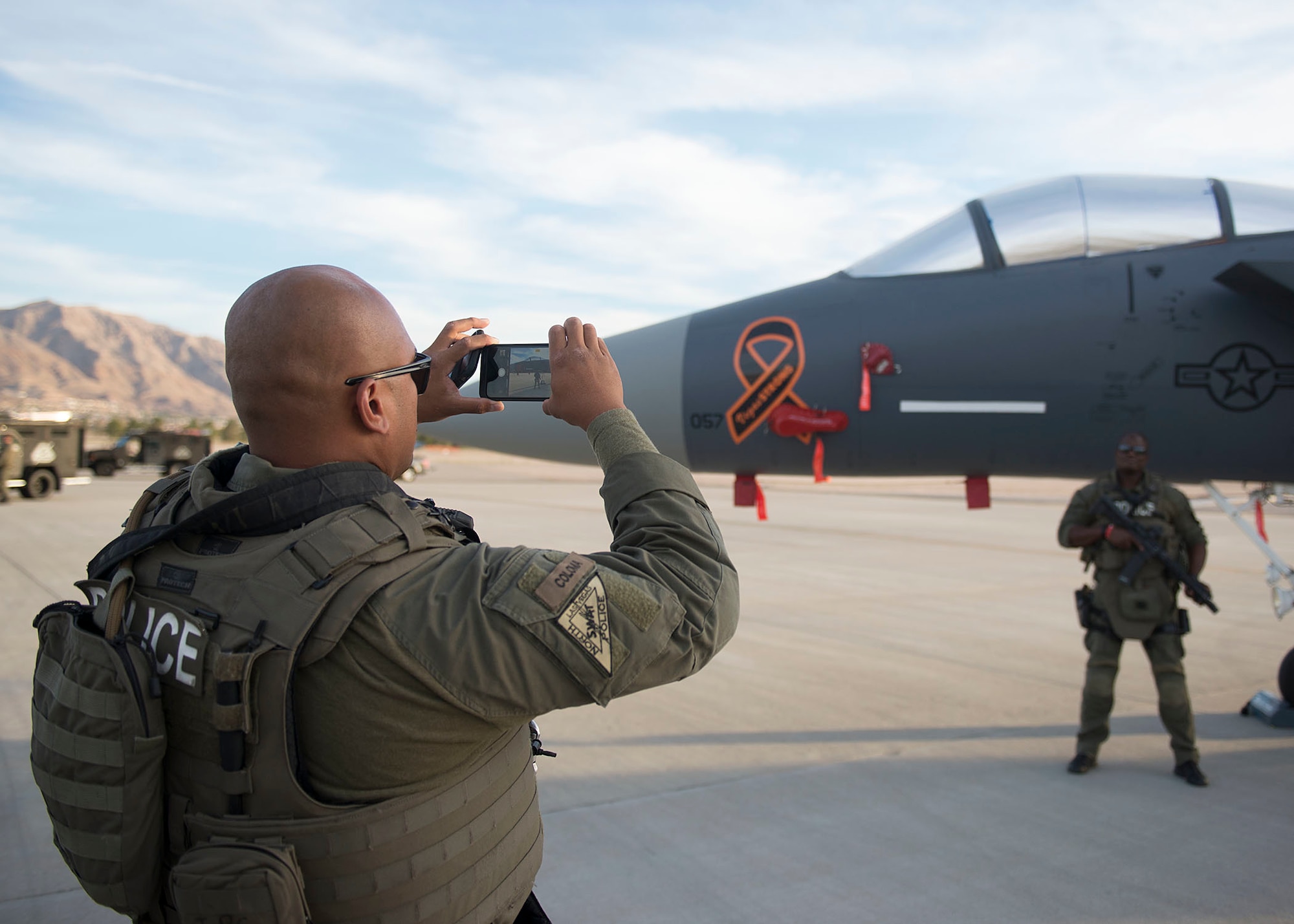 Members from the Northern Las Vegas Swat team take a picture in front a F-15 Eagle fighter jet on Nellis Air Force Base, Nevada, Nov. 2, 2018. The swat team visited to look at a vacant building to possibly perform training in. (U.S. Air Force photo by Airman 1st Class Bryan T. Guthrie)