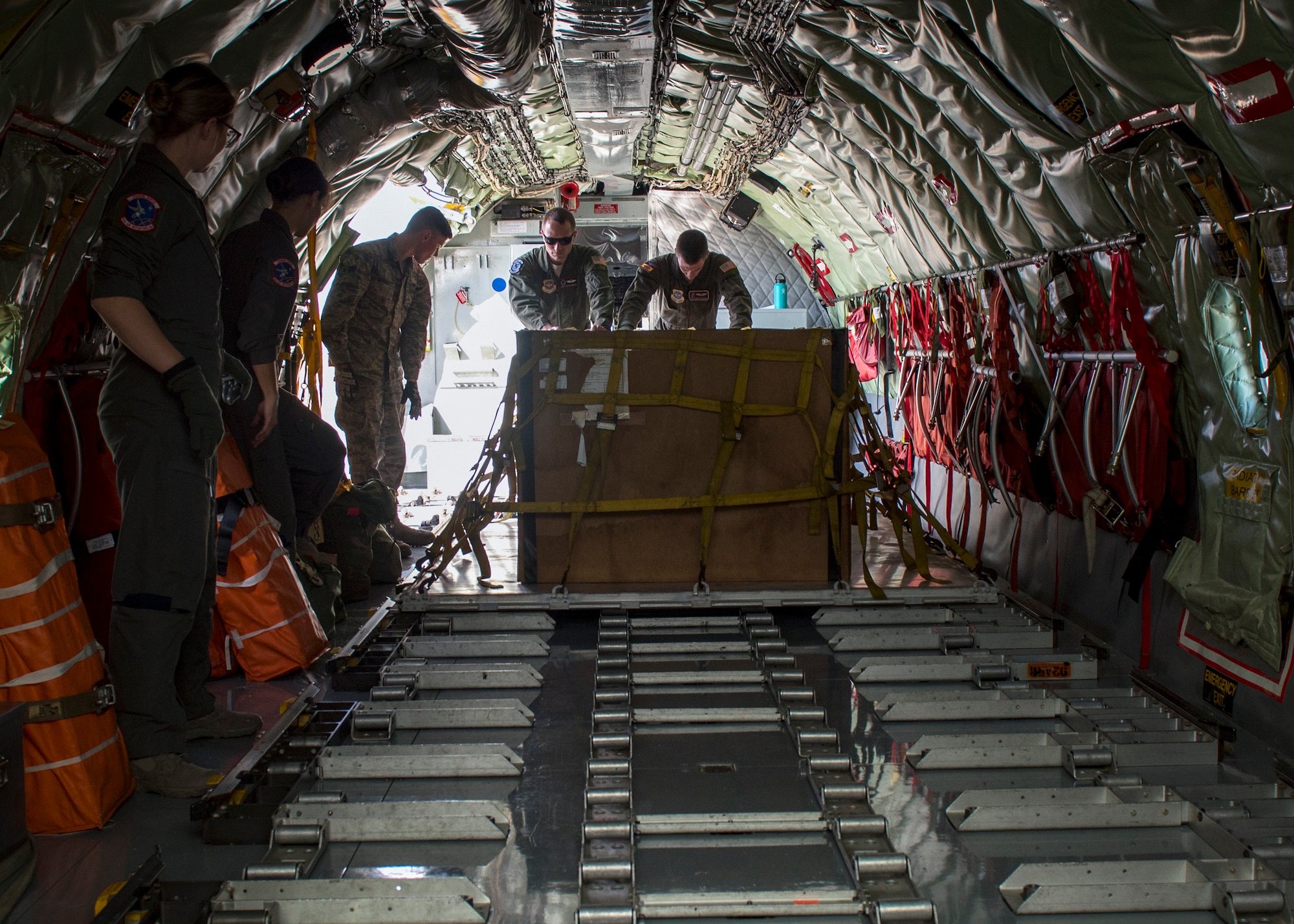 Aircrew load cargo onto a KC-135 Stratotanker during a cargo load training at Fairchild Air Force Base, Washington, Oct. 17, 2018. While other agencies load and transport cargo regularly, cargo load training is crucial for boom operators to remain proficient and effective when a KC-135 is tasked to transport cargo in addition to their primary role of in-flight refueling. (U.S. Air Force photo/Airman 1st Class Whitney Laine)