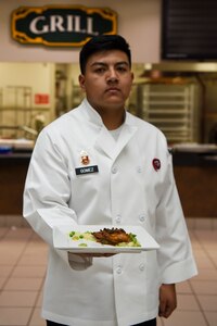 U.S. Army Pfc. Alejandro Gomez, a 2nd Battalion, 377th Parachute Field Artillery Regiment culinary specialist carries a dish to serve during the grand opening lunch for Joint Culinary Institute operated at the Gold Rush Inn. JCI is a new bi-monthly, two-week course, providing 10 food-service members from any military branch an opportunity to experience in-depth courses relating to the profession.