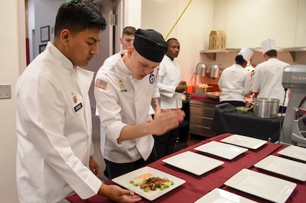 U.S. Army Sgt. Ethan Flagg, a 2nd Battalion, 377th Parachute Field Artillery Regiment culinary noncommissioned officer and Joint Culinary Institute instructor approves a dish for serving during the grand opening lunch for JCI operated at the Gold Rush Inn. JCI is a new bi-monthly, two-week course, providing 10 food-service members from any military branch an opportunity to experience in-depth courses relating to the profession.