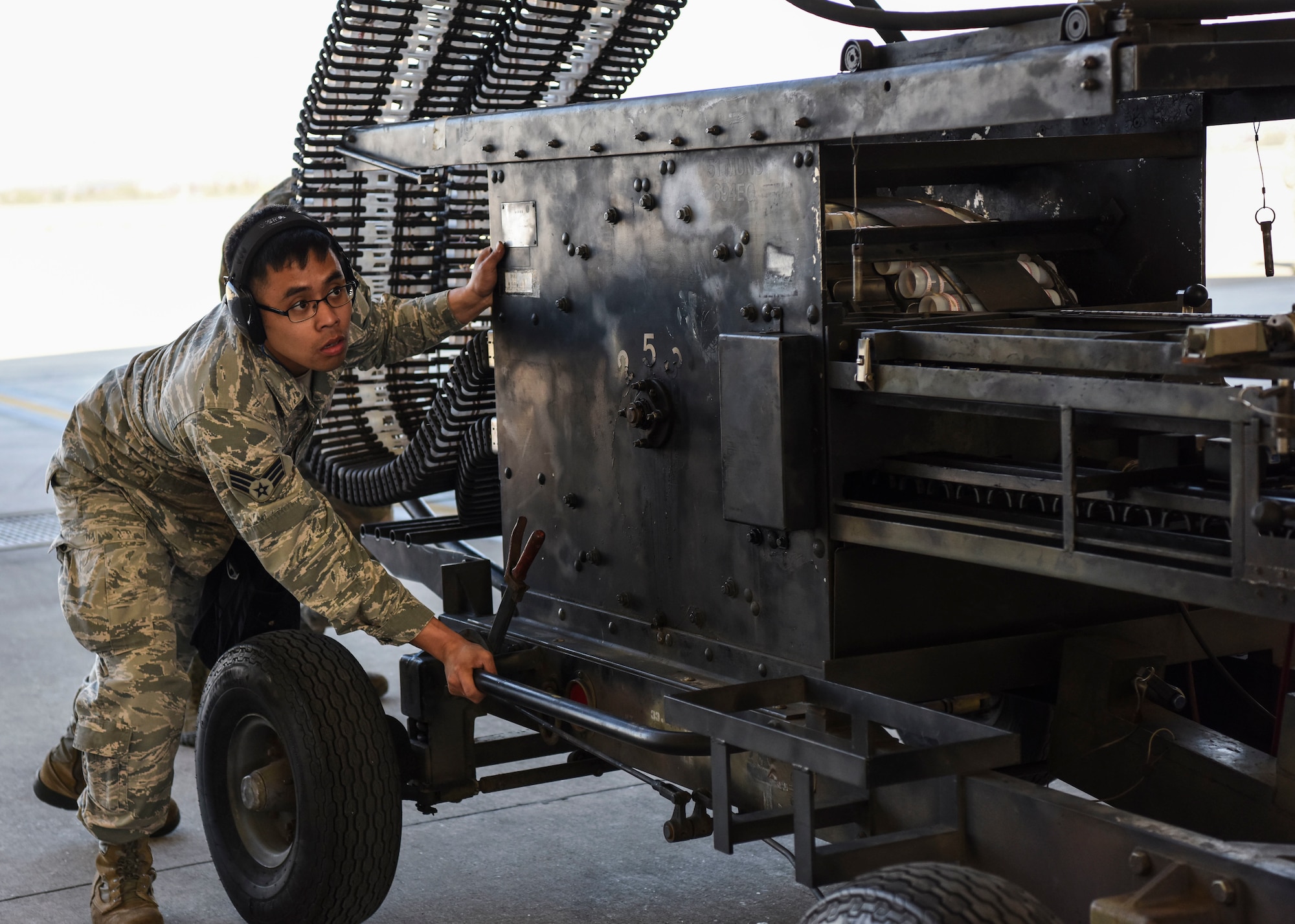 U.S. Air Force Senior Airman Ryan Alquetra, 51st Maintenance Group standardized load crew team member, moves a munitions loader into place before loading an aircraft at Osan Air Base, Republic of Korea, Nov. 2, 2018. Alquetra was able to ensure the munitions stayed in place as they loaded onto the aircraft through the conveyor system. (U.S. Air Force photo by Airman 1st Class Ilyana A. Escalona)