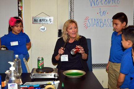 Kathy Martin, Starbase Kelly director, uses soda cans to demonstrate air pressure properties to Mildred Baskin Elementary students at Joint Base San Antonio-Lackland, Texas Nov. 5, 2018.