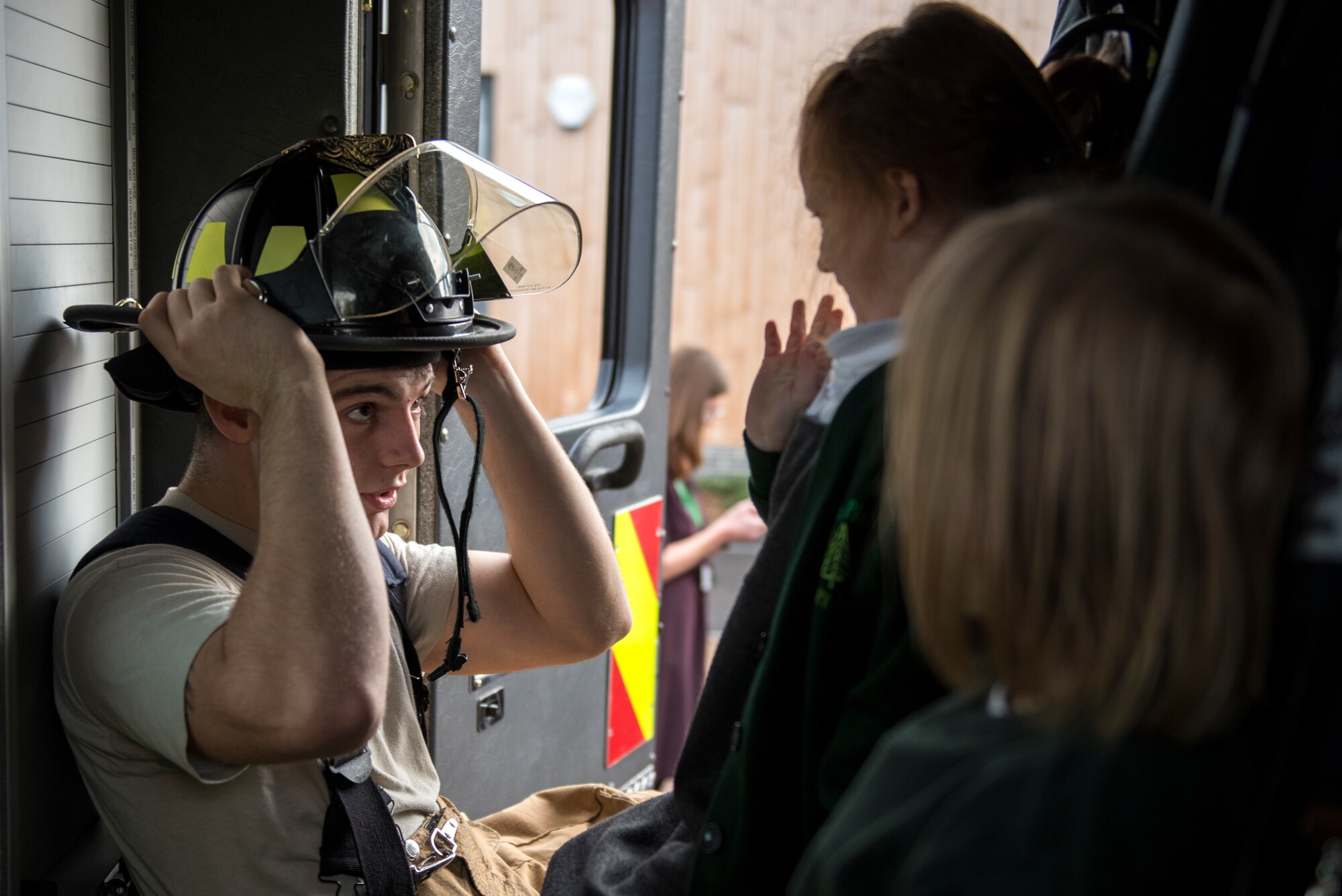 Airman 1st Class Darian Robley, 48th Civil Engineer Squadron firefighter, shows students his firefighting gear inside of a fire engine during an Everyday Heroes event at Pines Primary School in Red Lodge, England, Nov. 5. Each firefighter interacted with half a dozen children, and demonstrated various firefighting equipment and talked to them about what it means to be a real life hero. (U.S. Air Force Photo/ Senior Airman Malcolm Mayfield)