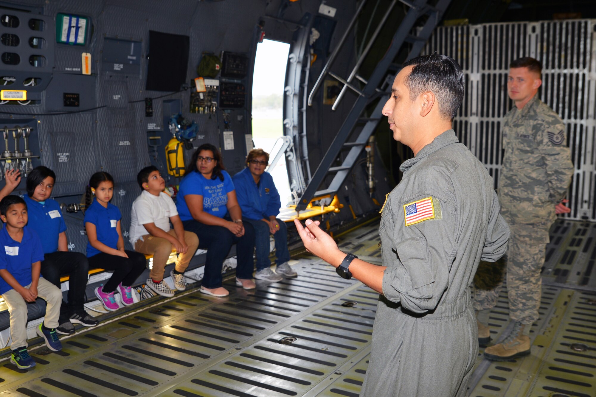 Staff Sgt. Anthony B. Molina, 68th Airlift Squadron flight engineer, and Tech. Sgt. Luke W. Christiansen, 433rd Maintenance Group, maintenance operations center production controller, describe the capabilities of the C-5M Super Galaxy to students with Mildred Baskin Elementary students at Joint Base San Antonio-Lackland, Texas Nov. 5, 2018.