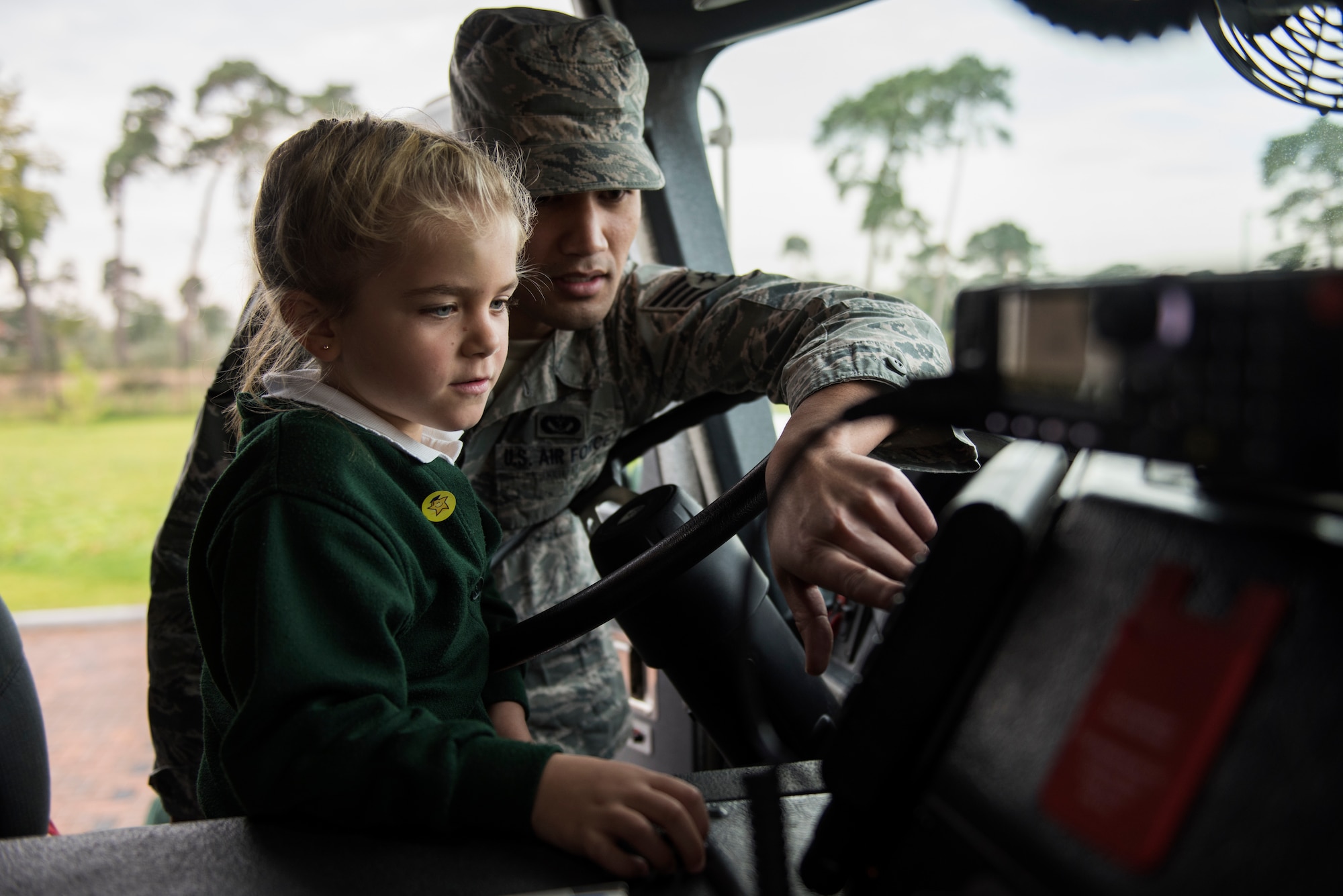 Staff Sgt. Robby Lamug, 48th Civil Engineer Squadron firefighter, shows a student the inside of a fire engine during an Everyday Heroes event at Pines Primary School in Red Lodge, England, Nov. 5. During the hour-and-a-half showcase, the firefighters provided the students with interactive demonstrations with life-saving equipment, such as the protective gear and firefighting gear, and enjoyed a full tour of a fire engine. (U.S. Air Force Photo/ Senior Airman Malcolm Mayfield)
