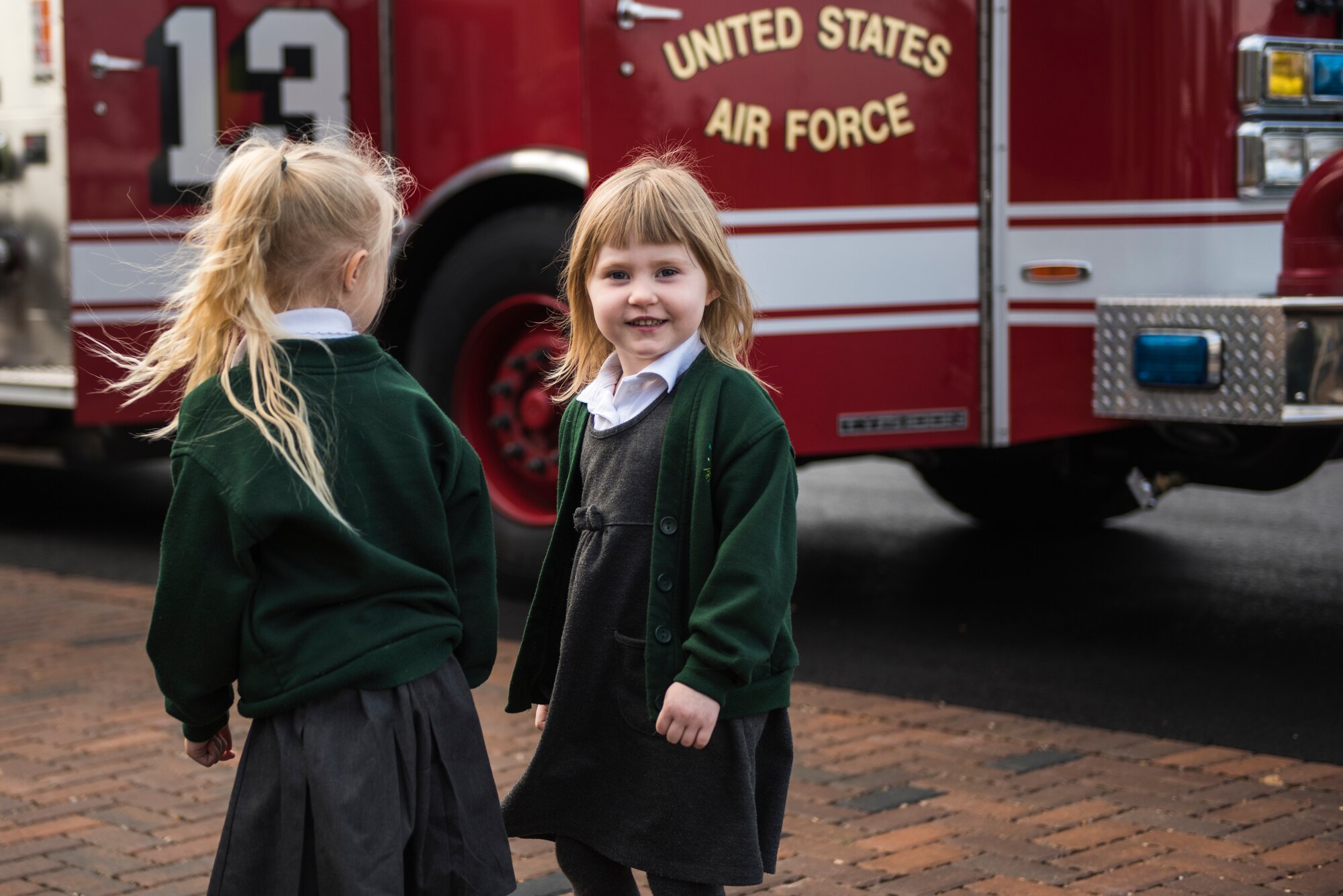 Two students from the Pines Primary walk past a fire engine assigned to 48th Civil Engineer Squadron during an Everyday Heroes event at Pines Primary School in Red Lodge, England, Nov. 5. The children were 4-to-5 years old and currently enrolled in their reception year. Each firefighter interacted with half a dozen children, and demonstrated various firefighting equipment and talked to them about what it means to be a real life hero. (U.S. Air Force Photo/ Senior Airman Malcolm Mayfield)