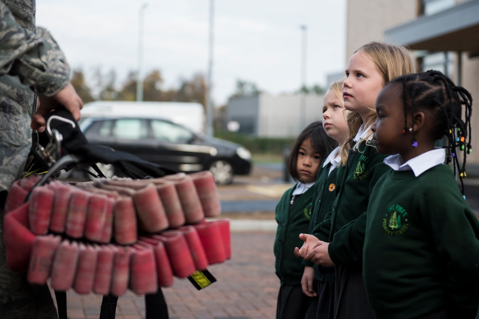 Students from the Pines Primary listen to 48th Civil Engineer Squadron firefighters as they display fire hoses and other equipment during an Everyday Heroes event at Pines Primary School in Red Lodge, England, Nov. 5. During the hour-and-a-half showcase, the firefighters provided the students an interactive demo with life-saving equipment and enjoyed a full tour of a fire engine. (U.S. Air Force Photo/ Senior Airman Malcolm Mayfield)