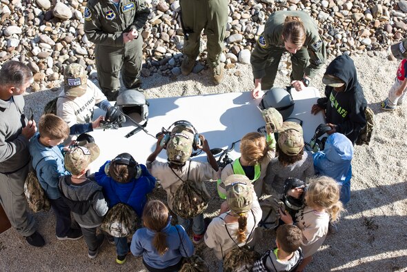 Junior deployers flock around a table where 86th Flying Training Squadron pilots display flight gear, which the children are able to try on at Laughlin Air Force Base, Texas on Nov. 3, 2018. November is the month of the military family, and Master Sgt. Crystal Beckham, 47th Force Support Squadron readiness NCO and 2018 Junior Deployment coordinator, says the base saw the junior deployment as a beneficial way to bring military and community members together. (U.S. Air Force photo by Airman 1st Class Anne McCready)