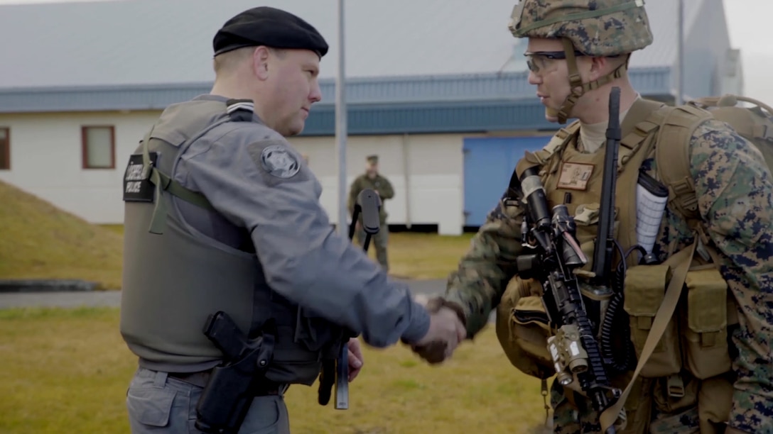 A U.S. Marine shakes hands with an Icelandic police officer.