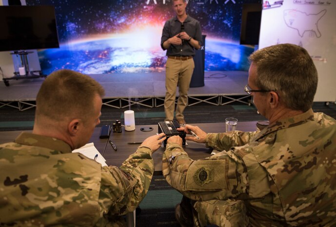 Lt. Col. Justin Elliott, 59th Test and Evaluation Squadron director of operations, presents his idea to Maj. Gen. Peter Gersten, U.S. Air Force Warfare Center commander, and Chief Master Sgt. Charles Hoffman, USAFWC command chief, at AFWERX-Vegas, Oct. 29, 2018. Elliot was one of the two presentations that was selected to advance to present in front of Air Combat Command. (U.S. Air Force photo by Airman 1st Class Andrew D. Sarver)
