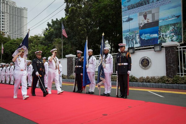Two Philippine military officers walk with the U.S. Chief of Naval Operations.
