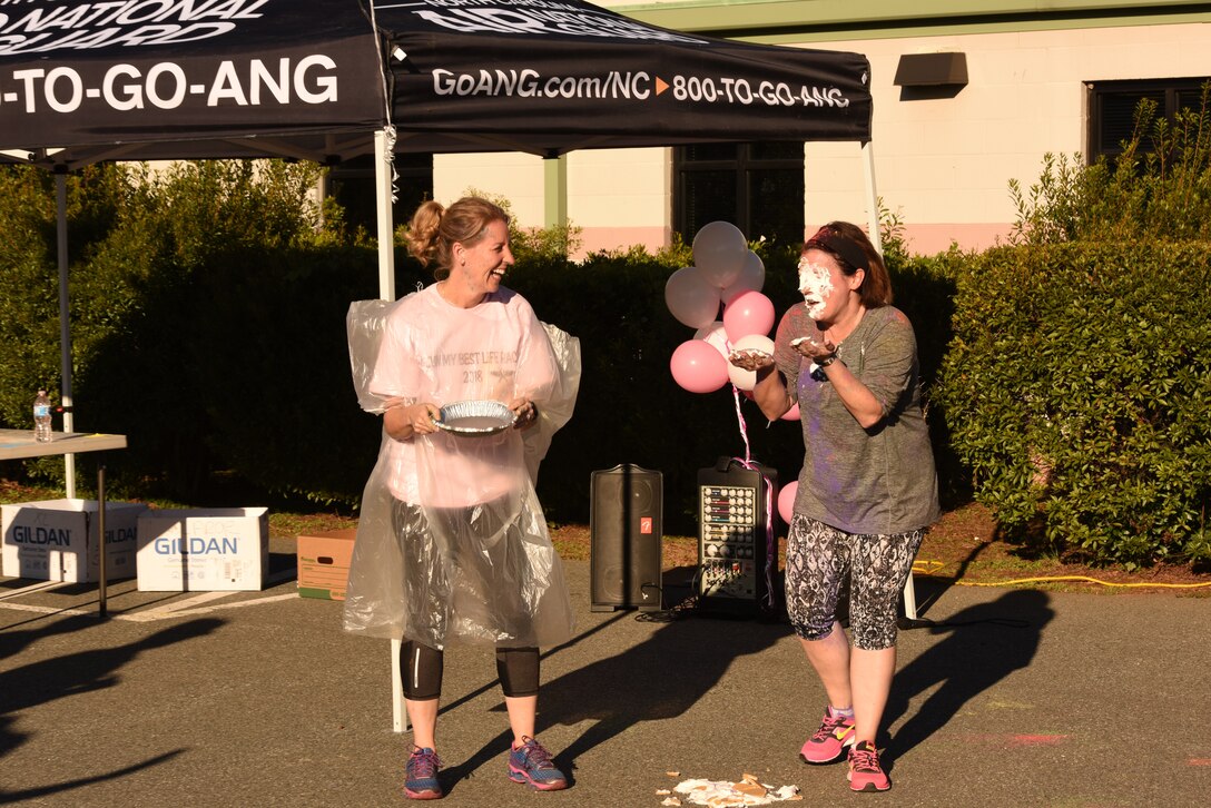U.S. Air Force Col. Bryony A. Terrell (left), 145th Airlift Wing commander, pies Lt. Col. Lisa Kirk, 145th Mission Support Group commander, in the face for a fundraising event following a ‘Living’ My Best Life’ Color Race, held at the North Carolina Air National Guard (NCANG) Base, Charlotte Douglas International Airport, Nov. 3, 2018. The Color Run, put together by the NCANG Recruiting Office, honors recently deceased U.S. Air Force Recruiter Master Sgt. Valanda Pettis, following her battle with cancer. Master Sgt. Pettis was believed by many to have a colorful personality and would often be heard singing, ‘Livin’ My Best Life,’ during the good and bad days; a true testament to her strength.