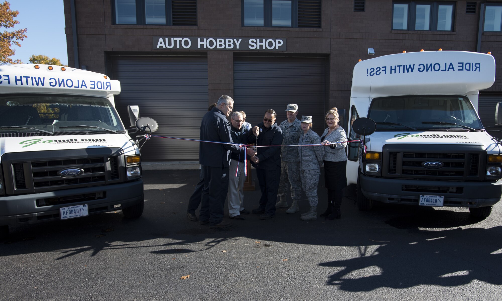 U.S. Air Force Col. Neil Richardson, Joint Base McGuire-Dix-Lakehurst and 87th Air Base Wing commander, and U.S. Air Force Lt. Col. Paula Cottrell, 87th Force Support Squadron commander, prepare to cut a ribbon with government officials and staff during a ceremony marking the reopening of the Auto Hobby Shop on Joint Base MDL, New Jersey, Nov. 7, 2018. The renovation plans of the shop began in 2008 but construction was suspended in 2012 before resuming in 2016. (U.S. Air Force photo by Airman 1st Class Ariel Owings)