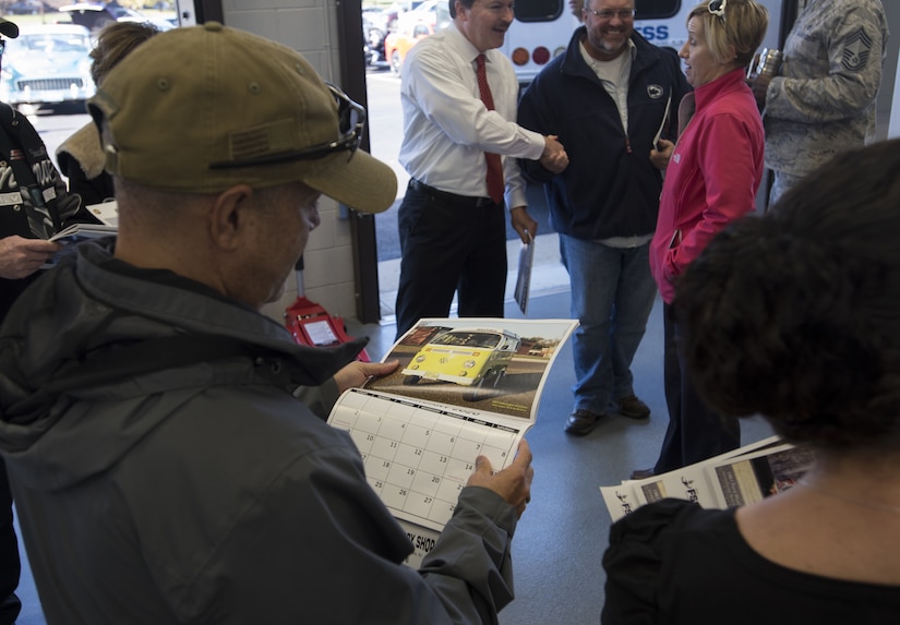 A Joint Base McGuire-Dix-Lakehurst community member looks at an automobile calendar during a ceremony marking the reopening of the Auto Hobby Shop on Joint Base MDL, New Jersey, Nov. 7, 2018. The multi-functional 18 bay facility will provide vehicle services such as diagnostic scans, preventative maintenance, lube/oil and filter changes and more.  The shop is open to all eligible DoD ID card holders for self-services. (U.S. Air Force photo by Airman 1st Class Ariel Owings)