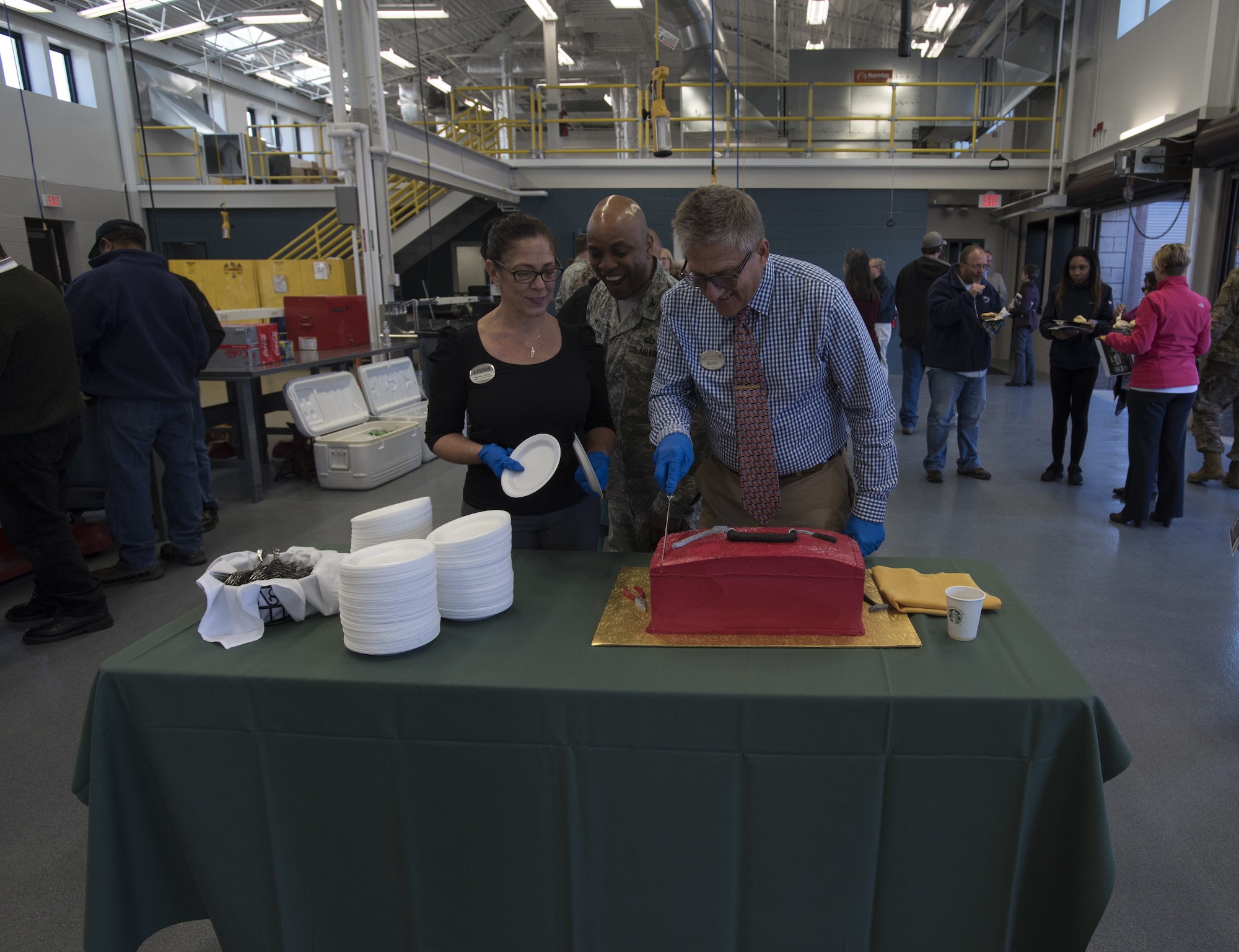 Marianne Tatcher, 87th Force Support Squadron community center director, Ernist Yeager, 87th FSS outdoor recreation director, and U.S. Air Force Col. Dalian Washington, 87th Mission Support Group commander, cut a cake during a ceremony marking the reopening of the Auto Hobby Shop on Joint Base MDL, New Jersey, Nov. 7, 2018. The $4.1 million dollar project was a combination of $3.1 million dollars of Non-Appropriated Funds and $966K of Appropriated Funds and was awarded to David Stroehlein, Volmar Construction global traffic manager, in 2016 to finish the renovations. (U.S. Air Force photo by Airman 1st Class Ariel Owings)
