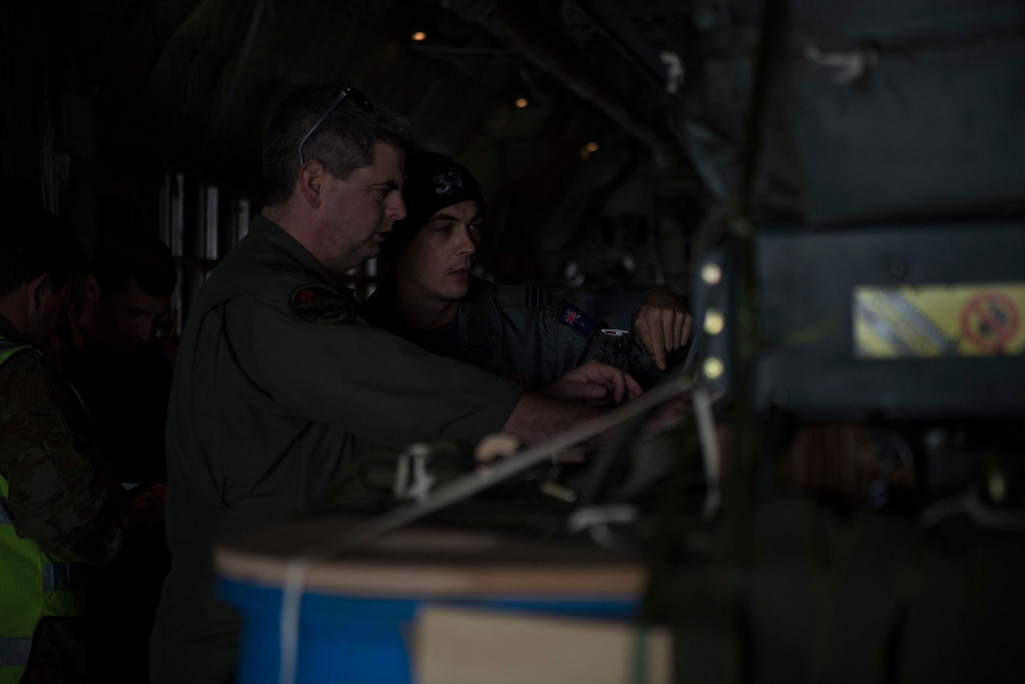 Image of Royal Australian Air Force pilots perform the role of a Precision Aerial Delivery System Operator before a flight at Mountain Home Air Force Base, Idaho, Nov. 1, 2018. The pilots are programming the cargo to self-navigate when dropped from the C-130J Super Hercules. (U.S. Air Force photo by Senior Airman Alaysia Berry)