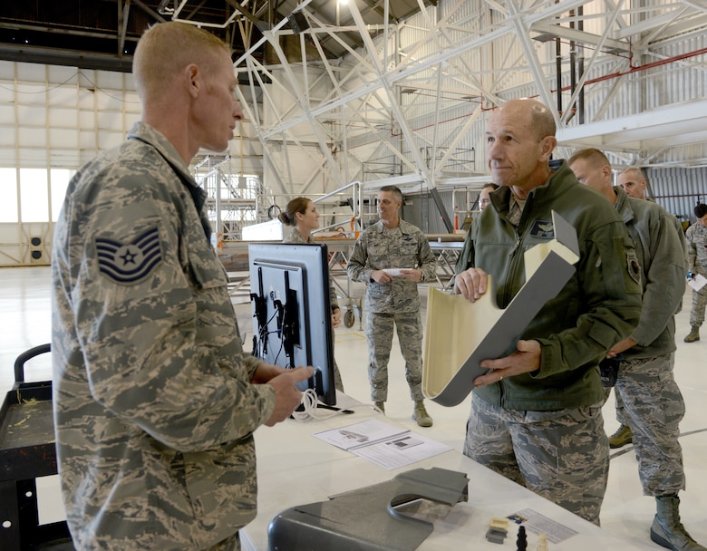 Tech. Sgt. Joshua Rea, with the 552nd Maintenance Squadron's Fabrication Flight, speaks to Gen. Mike Holmes, commander Air Combat Command, about the operations within their shop and the products they are able to reproduce with their 3-D printers, such as the pilot's seat shroud the General is holding.