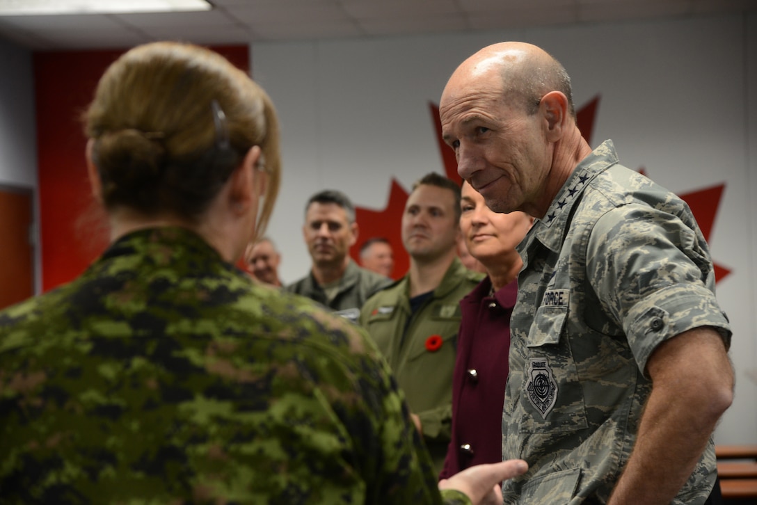 Gen. Mike Holmes, commander Air Combat Command, listens to Master Warrant Officer Lisa Powers, with the 552nd Air Control Wing Canadian Detachment, as she emphasizes the importance of the strategic relationship between the U.S. and Canada and also provides him with an overview of their flying unit operaitons and working environment during his Nov. 1 visit to Tinker.