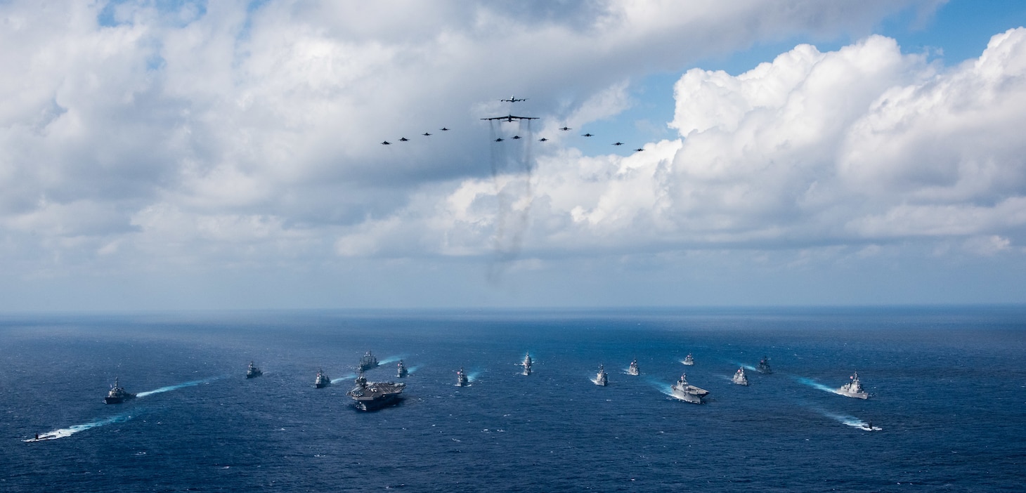 PHILIPPINE SEA (Nov. 8, 2018)The aircraft carrier USS Ronald Reagan (CVN 76), left, and the Japanese helicopter destroyer JS Hyuga (DDH 181), right, sail in formation with 16 other ships from the U.S. Navy and Japan Maritime Self-Defense Force (JMSDF) as aircraft from the U.S. Air Force and Japan Air Self-Defense Force fly overhead in formation during Keen Sword 2019. Keen Sword 2019 is a joint, bilateral field-training exercise involving U.S. military and JMSDF personnel, designed to increase combat readiness and interoperability of the Japan-U.S. alliance.
