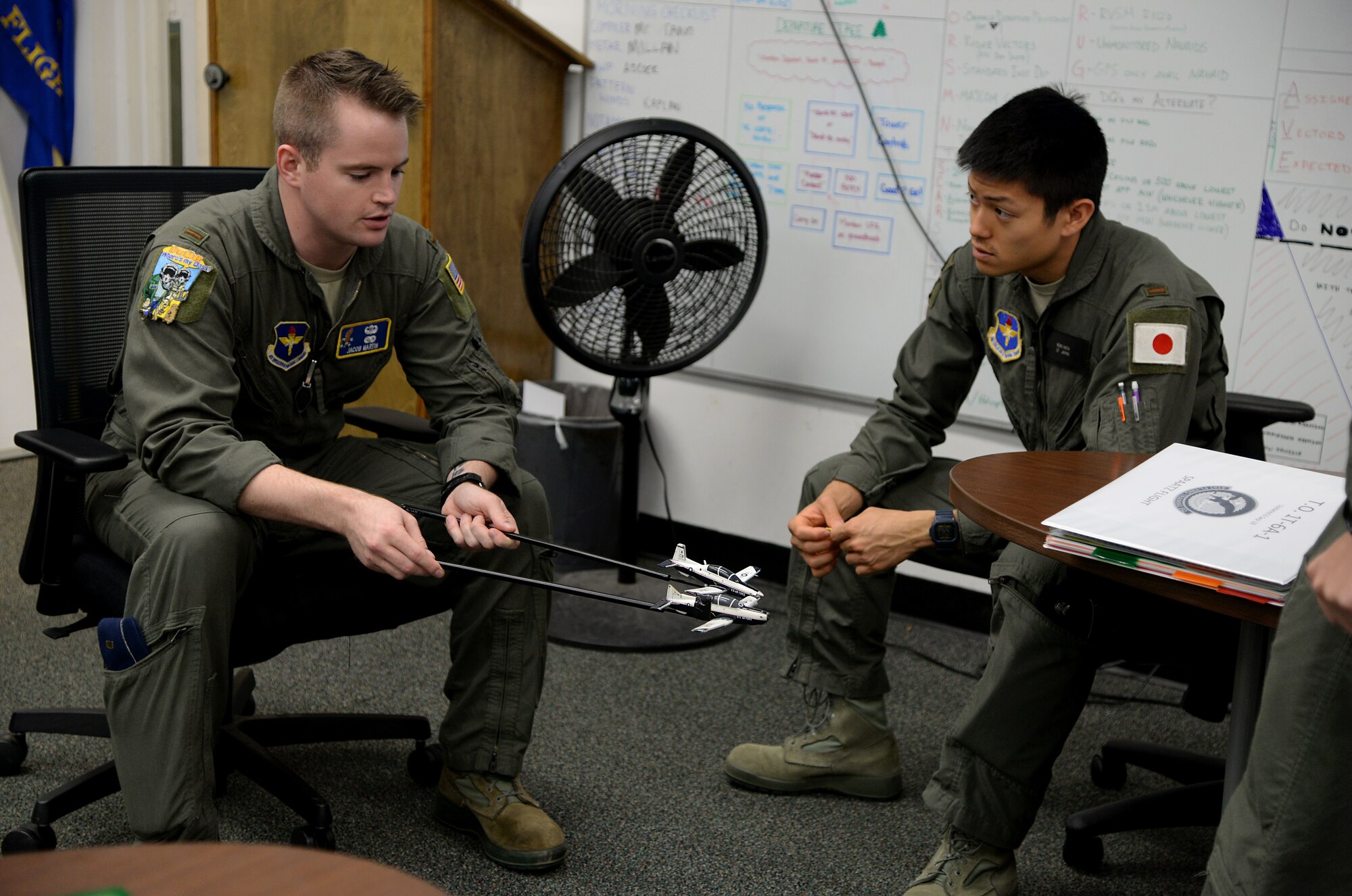 Second Lt. Jacob Martin, 14th Student Squadron student pilot, demonstrates an aerial maneuver to Koki Hata, 14th STUS student pilot, with prop T-6 Texan II’s Nov. 5, 2018, on Columbus Air Force Base, Mississippi. Students work together throughout pilot training to learn new or different ways to approach aviation. (U.S. Air Force photo by Airman 1st Class Keith Holcomb)