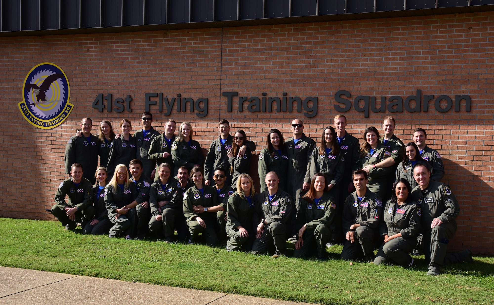 Instructor pilots 41st Flying Training Squadron stand with their spouses Nov. 2, 2018, on Columbus Air Force Base, Mississippi. Spouse flights are annual for the 14th Operations Group to thank spouses as well as show them firsthand what their uniformed family members do every day at work to complete their mission. (U.S. Air Force photo by Elizabeth Owens)