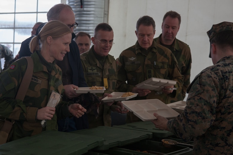 U.S.  Marines with 2nd Marine Logistics Group-Forward (2nd MLG-Fwd) serve lunch to Norwegian military members, in Stjødal, Norway,Nov. 5, 2018. Leaders of the Norwegian military met with leaders and noncommissioned officers (NCOs) of 2nd MLG-Fwd to discuss the role of the Marine Corps NCO during Exercise Trident Juncture 18. The exercise enhances the U.S. and NATO Allies’ and partners’ abilities to work together collectively to conduct military operations under challenging conditions. (U.S. Marine Corps photo by Lance Cpl. Scott R. Jenkins)