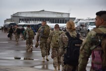 Airmen from the 819th Rapid Engineer Deployable Heavy Operational Repair Squadron Engineers (RED HORSE) walk across the flight line Nov. 5, 2018, at Great Falls International Airport, Mont. Seventy RED HORSE Airmen served for U.S. Africa Command and 100 Airmen served for U.S. Air Forces Central Command. (U.S. Air Force photo by Airman 1st Class Jacob M. Thompson)