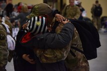 An Airmen from the 819th Rapid Engineer Deployable Heavy Operational Repair Squadron Engineers (RED HORSE) hugs a family member Nov. 5, 2018, at the airfields located on Malmstrom Air Force Base, Mont. One hundred RED HORSE Airmen returned home and were greeted by family and friends. (U.S. Air Force photo by Airman 1st Class Jacob M. Thompson)