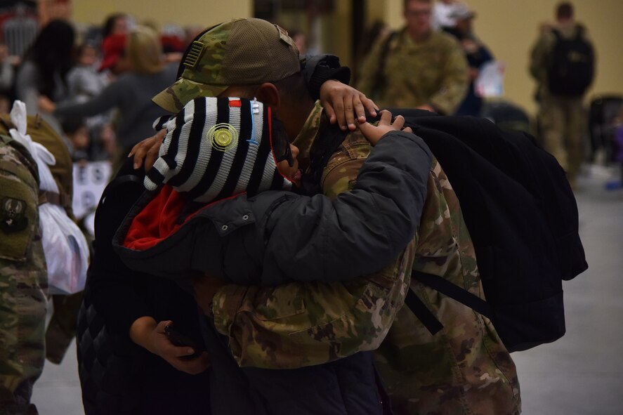 An Airmen from the 819th Rapid Engineer Deployable Heavy Operational Repair Squadron Engineers (RED HORSE) hugs a family member Nov. 5, 2018, at the airfields located on Malmstrom Air Force Base, Mont. One hundred RED HORSE Airmen returned home and were greeted by family and friends. (U.S. Air Force photo by Airman 1st Class Jacob M. Thompson)