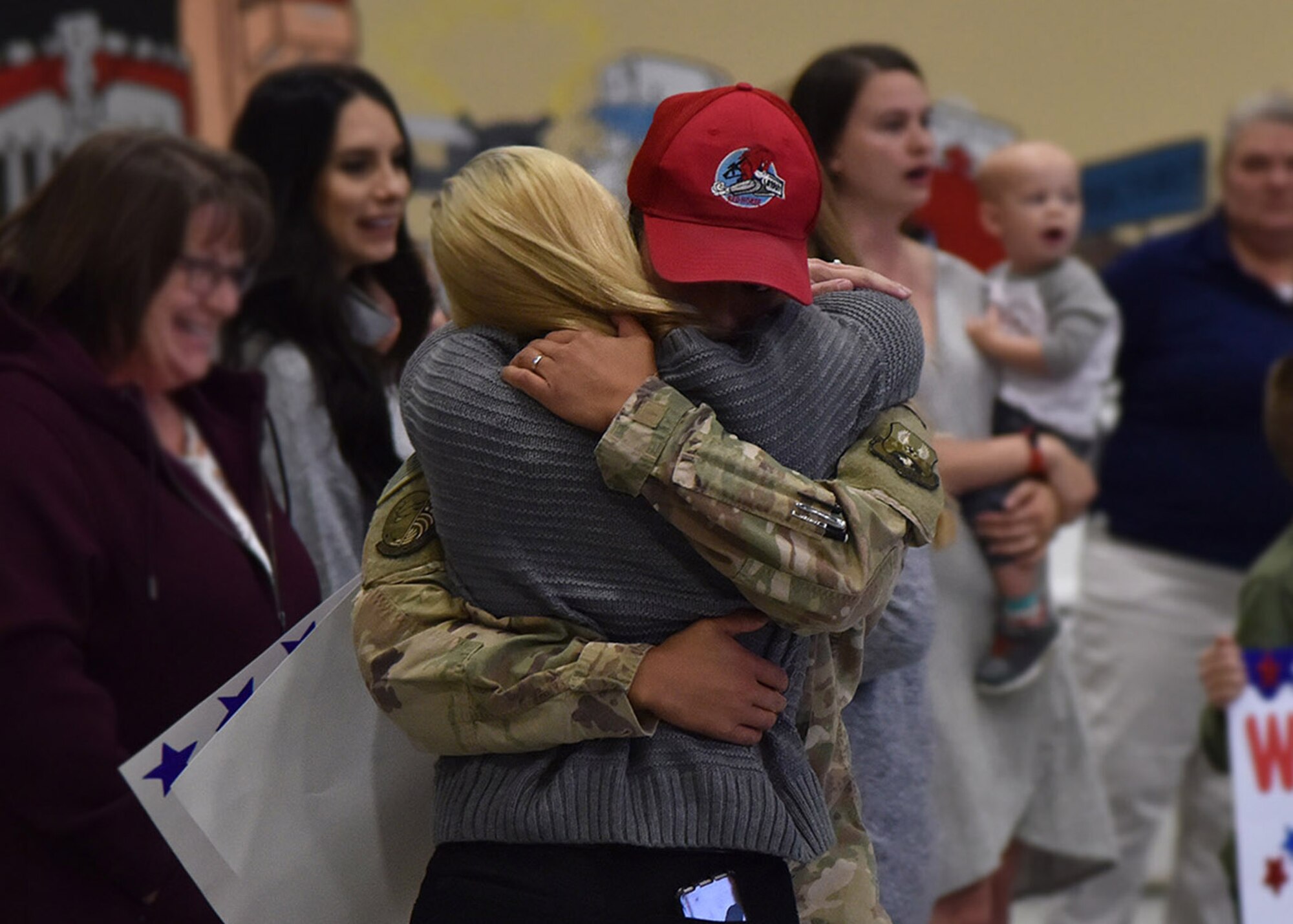 An Airman from the 819th Rapid Engineer Deployable Heavy Operational Repair Squadron Engineers (RED HORSE) hugs a family member Nov. 5, 2018, at the airfields located on Malmstrom Air Force Base, Mont. The 819th RED HORSE U.S. Air Forces Central Command team, as part of the 1st Expeditionary Civil Engineer Group, supported construction in the Middle East, building a command center vital to the fight against terrorism. (U.S. Air Force photo by Airman 1st Class Jacob M. Thompson)