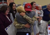 An Airman from the 819th Rapid Engineer Deployable Heavy Operational Repair Squadron Engineers (RED HORSE) hugs a family member Nov. 5, 2018, at the airfields located on Malmstrom Air Force Base, Mont. The 819th RED HORSE U.S. Air Forces Central Command team, as part of the 1st Expeditionary Civil Engineer Group, supported construction in the Middle East, building a command center vital to the fight against terrorism. (U.S. Air Force photo by Airman 1st Class Jacob M. Thompson)