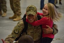 An Airman from the 819th Rapid Engineer Deployable Heavy Operational Repair Squadron Engineers (RED HORSE) hugs his children Nov. 5, 2018, at the airfields located on Malmstrom Air Force Base, Mont. The 819th RED HORSE U.S. Africa Command team shared in multi-agency base building efforts for Air Base 201 in Agadez, Niger, an expeditionary installation being constructed in one of the most remote regions in Africa. (U.S. Air Force photo by Airman 1st Class Jacob M. Thompson)
