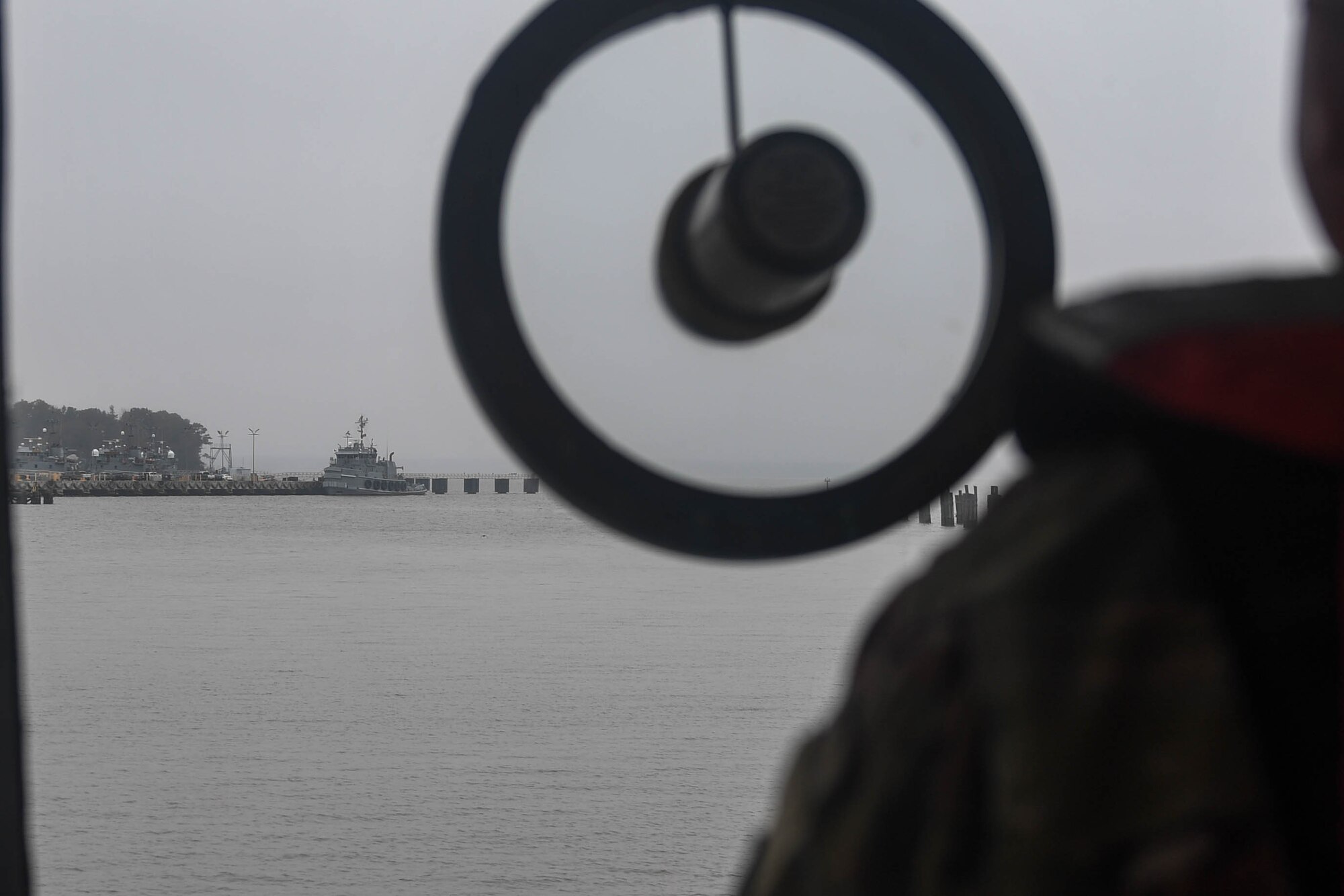 U.S. Army Sgt. 1st Class William Littell, 73rd Transportation Company, 10th Trans. Battalion, 7th Trans. Brigade (Expeditionary) licensing vessel master, steers a 900-series Small Tug out of Third Port at Joint Base Langley-Eustis, Virginia, Nov. 5, 2018. The 73rd Trans. Co. participates and operates in river and over the shore for Joint Logistics Operations Training operations. (U.S. Air Force photo by Senior Airman Derek Seifert)