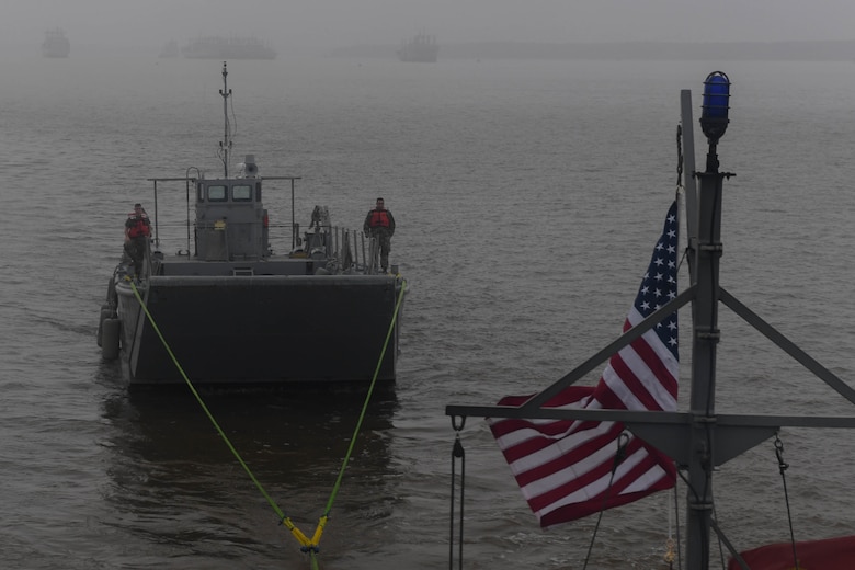 A Landing Craft Mechanized, Mark 8 is towed in the Chesapeake Bay during towing training at Joint Base Langley-Eustis, Virginia, Nov. 5, 2018. The Small Tug is capable of towing up to 37,000 pounds, which includes a variety in size of vessels to support the installation and brigade taskings. (U.S. Air Force photo by Senior Airman Derek Seifert)