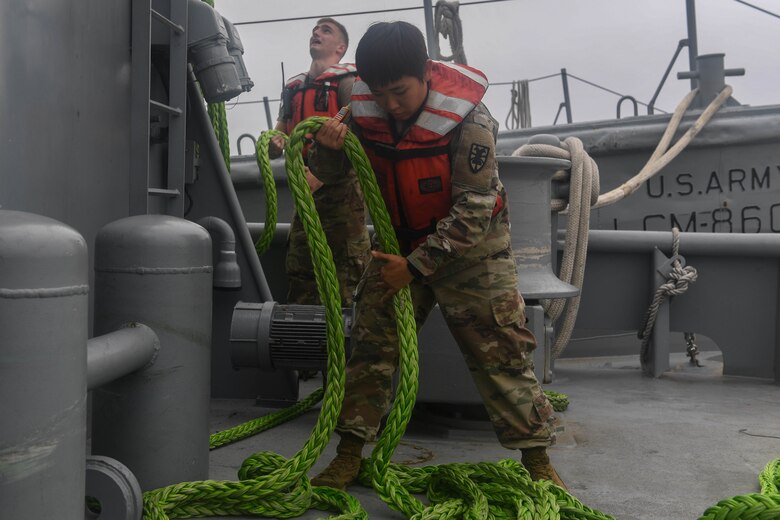 U.S. Army Spc. Mi Rea Lee, 73rd Transportation Company, 10th Trans. Battalion, 7th Trans. Brigade (Expeditionary) seaman, prepares rope to be stowed correctly after towing training at Joint Base Langley-Eustis, Virginia, Nov. 5, 2018. The tow lines that are used by the crew vary in size, weight and length which provides the crew options when deciding the best way to tow a vessel. (U.S. Air Force photo by Senior Airman Derek Seifert)