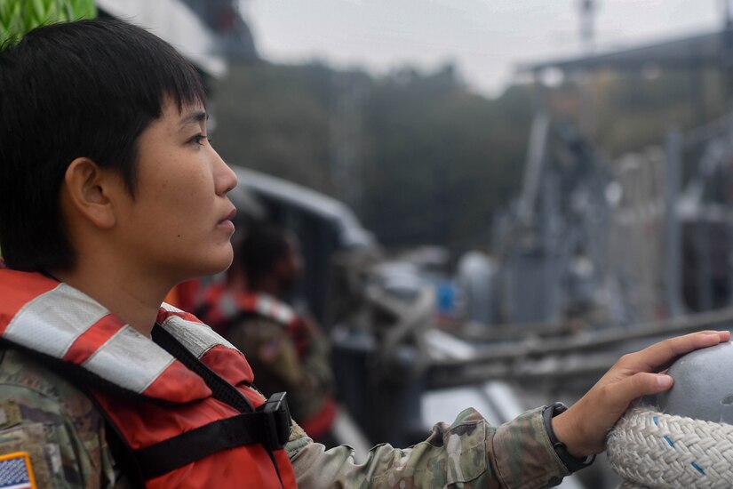 U.S. Army Spc. Mi Rea Lee, 73rd Transportation Company, 10th Trans. Battalion, 7th Trans. Brigade (Expeditionary) seaman, looks over the side of a 900-series Small Tug at Joint Base Langley-Eustis, Virginia, Nov. 5, 2018. The crew for a Small Tug consists of a vessel master, chief engineer, five watercraft operators and four watercraft engineers. (U.S. Air Force photo by Senior Airman Derek Seifert)