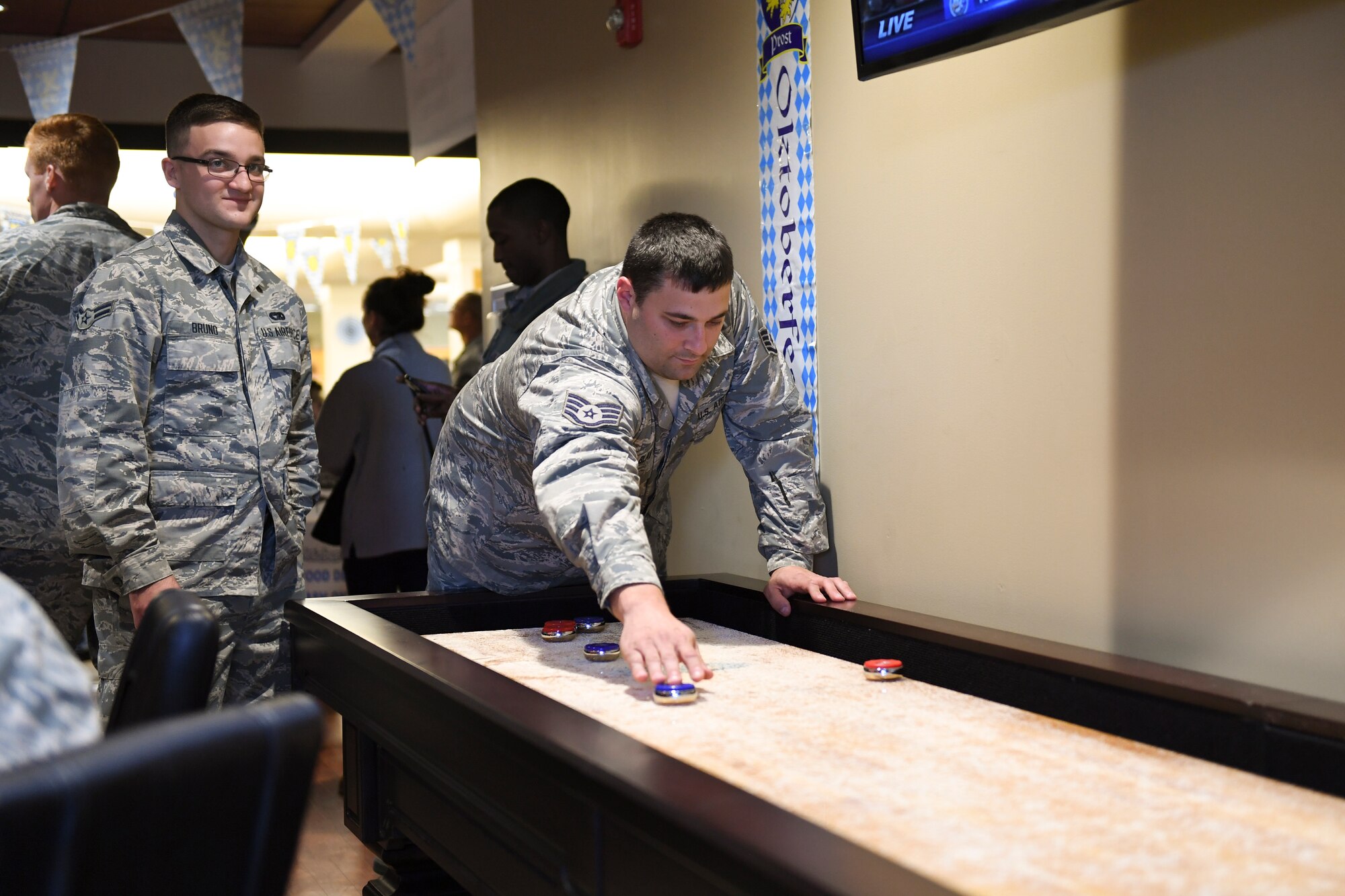 Airmen from the 911th Airlift Wing play table shuffleboard at the Pittsburgh International Airport Air Reserve Station, Pennsylvania, October 3, 2018. This was part of an Oktoberfest event in an effort to boost morale and let Airmen relax after a very busy year and a half. (U.S. Air Force photo by Senior Airman Beth Kobily)