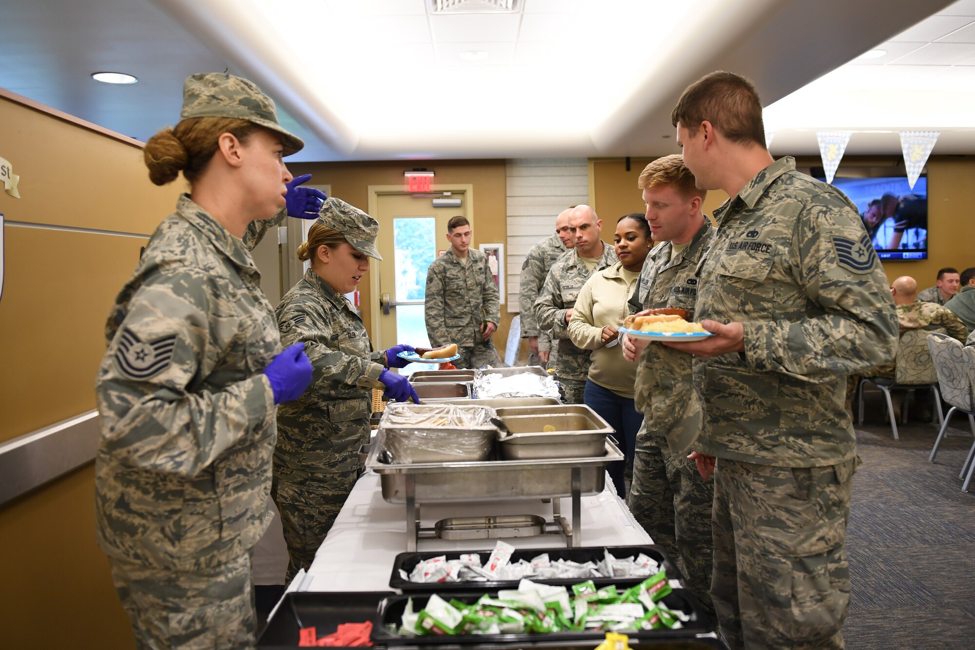 Airmen from the 911th Airlift Wing serve kielbasa and saurkraut at the Pittsburgh International Airport Air Reserve Station, Pennsylvania, October 3, 2018. This was part of an Oktoberfest event in an effort to boost morale and let Airmen relax after a very busy year and a half. (U.S. Air Force photo by Senior Airman Beth Kobily)