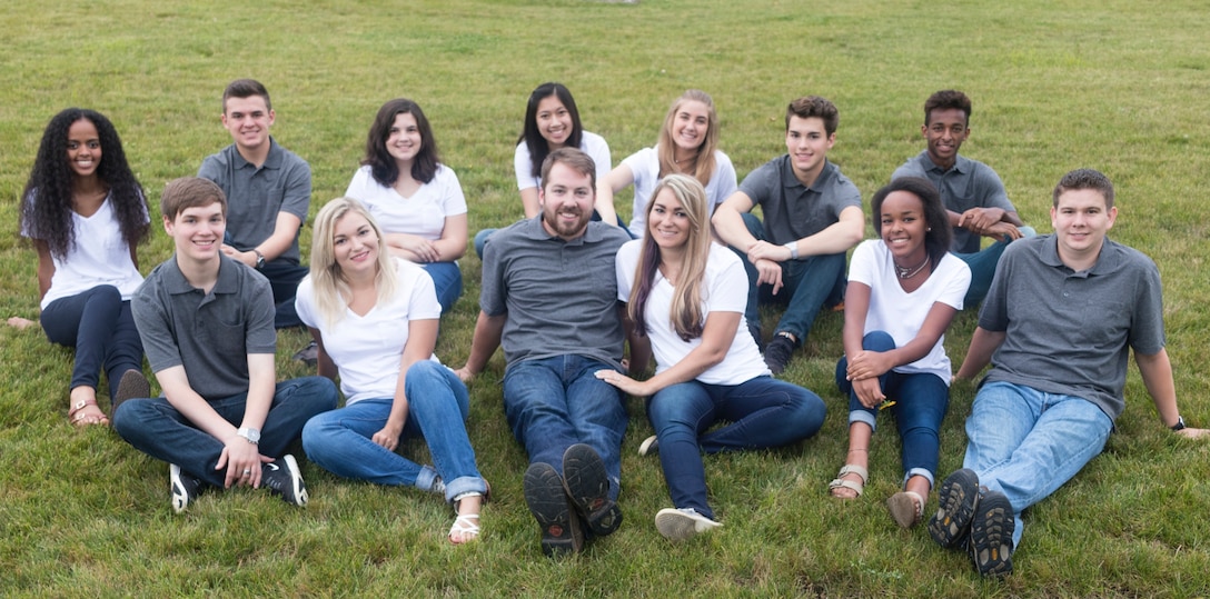 12 siblings sit in grass