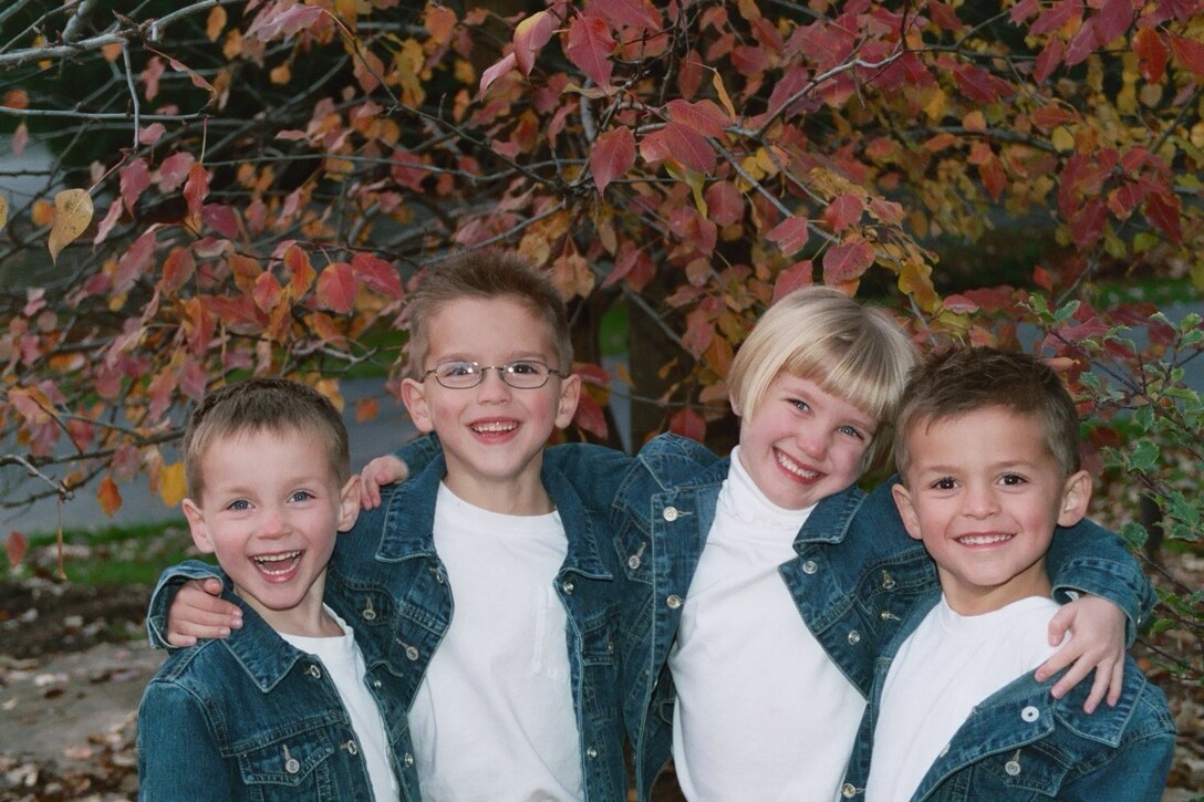 Quadruplets pose in matching outfits at a young age