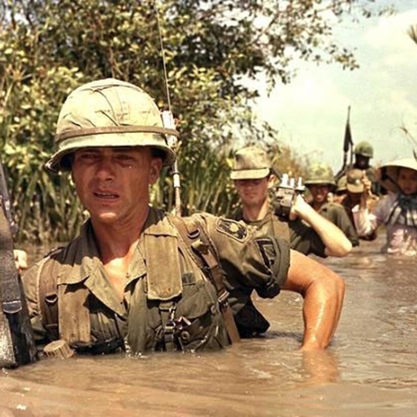 A soldier in South Vietnam takes the lead in chest-deep water.