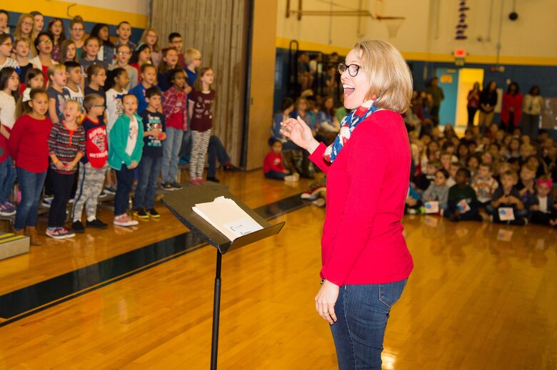 Diane Walls, George Welch Elementary School choir director, leads the choir in the singing of “The U.S. Air Force” song at a Veterans Day celebration Nov. 9, 2018, at Dover Air Force Base Middle School, Dover Air Force Base, Del. The choir performed songs in honor of each of the five military branches and the veterans in attendance. (U.S. Air Force photo by Mauricio Campino)