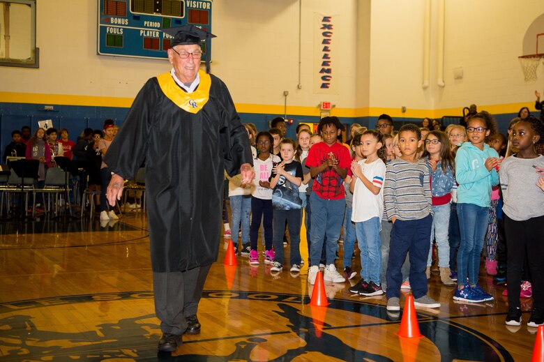 Retired U.S. Air Force Master Sgt. Leo Tos is made an honorary graduate of the Caesar Rodney School District during a Veterans Day celebration Nov. 9, 2018, at Dover Air Force Base Middle School, Dover Air Force Base, Del. Tos never attended his high school graduation because he was drafted into the U.S. Navy a month before the ceremony. (U.S. Air Force photo by Mauricio Campino)