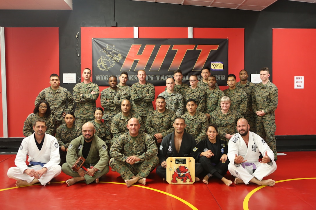 Marines with Marine Corps Air Station Miramar and members with Carlson Gracie Brazilian Jiu-Jitsu pose for a group photo after a submission seminar at the High Intensity Tactical Training center on Marine Corps Air Station Miramar, Calif., Nov. 8. Carlson Gracie Brazilian Jiu-Jitsu hosted an advanced submission class and seminar on power resiliency for Marines stationed at MCAS Miramar to boost confidence and improve self-defense skills. (U.S. Marine Corps photo by Sgt. Daniel Auvert.)