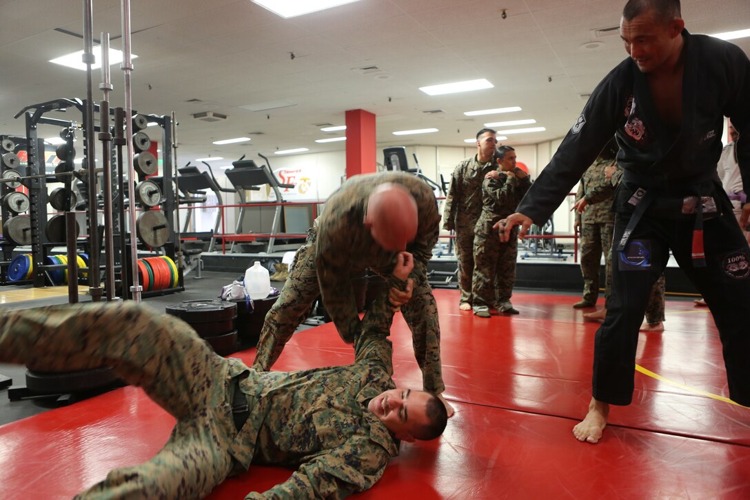 Master Gunnery Sgt. Marcus R. Dawson, staff non-commissioned officer in charge of Installation Personnel Administration Center, drills a throwing technique during a submission seminar at the High Intensity Tactical Training center on Marine Corps Air Station Miramar, Calif., Nov. 8. Carlson Gracie Brazilian Jiu-Jitsu hosted an advanced submission class and seminar on power resiliency for Marines stationed at MCAS Miramar to boost confidence and improve self-defense skills. (U.S. Marine Corps photo by Sgt. Daniel Auvert.)
