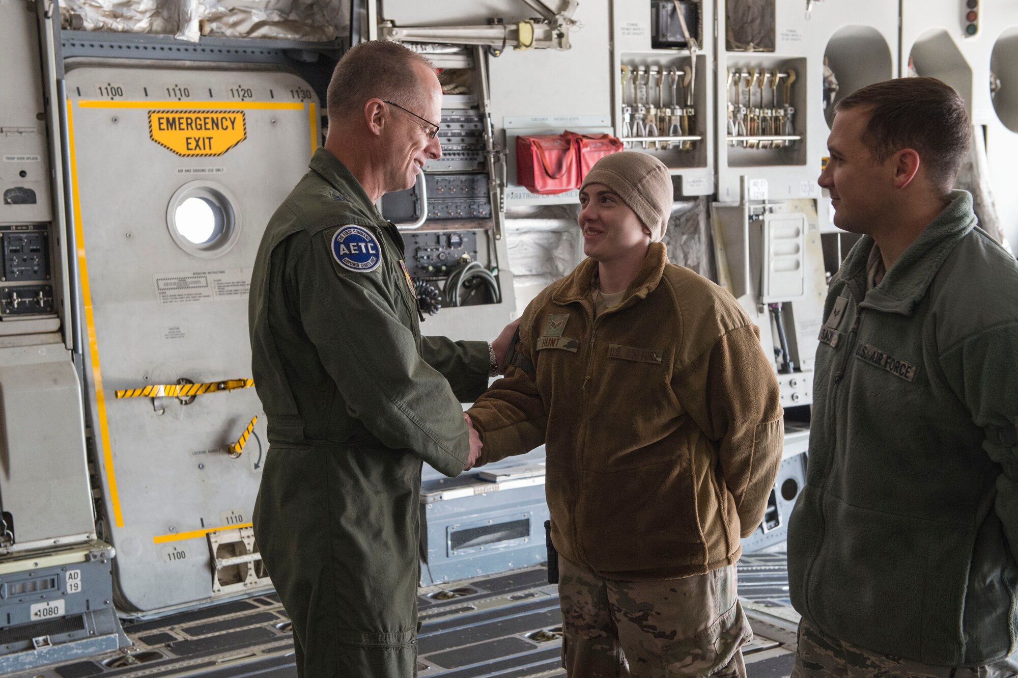 U.S. Air Force Maj. Gen. Mark Weatherington, Air Education and Training Command deputy commander, greets Senior Airman Kayla Hunt and Airman 1st Class Logan Sacks, both aerial delivery members assigned to the 97th Logistics Readiness Squadron, Nov. 8, 2018, at Altus Air Force Base, Okla. The 97th LRS showcased loading cargo onto a C-17 Globemaster III to Weatherington as part of the tour to showcase the base’s capabilities. (U.S. Air Force photo by Senior Airman Cody Dowell)